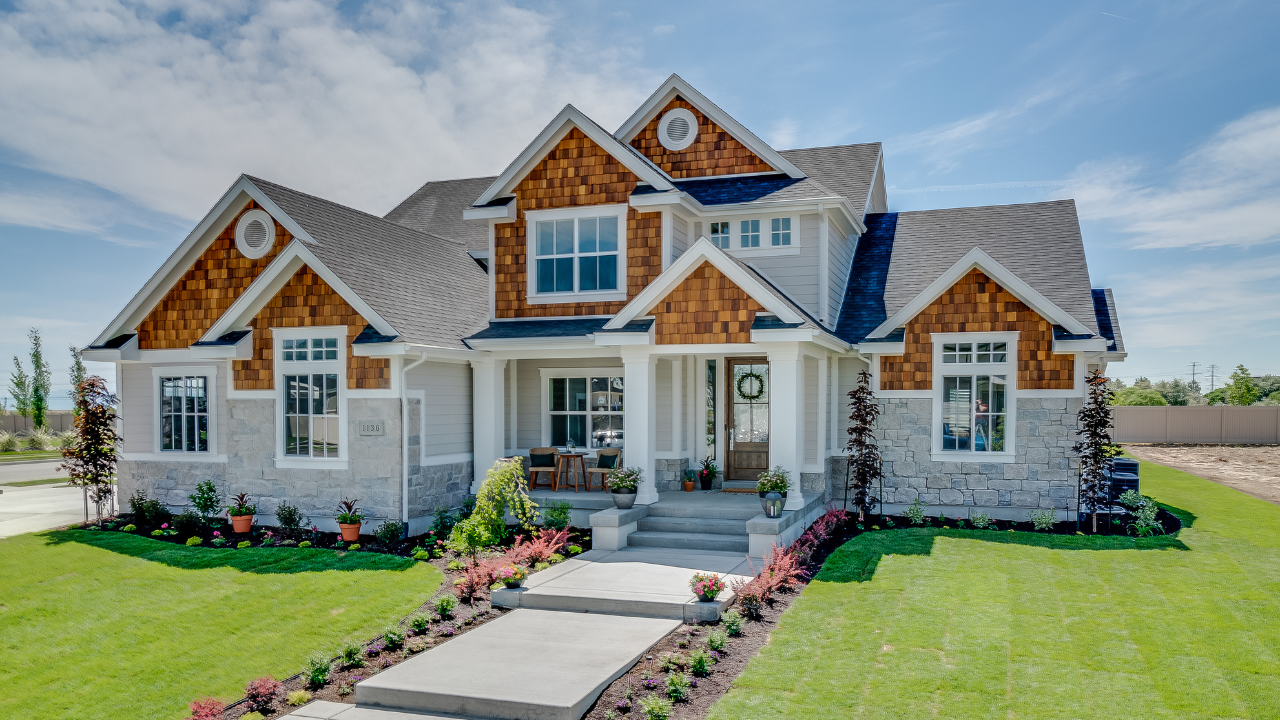 Beautiful modern suburban home with a well-maintained front yard, stone accents, and wooden siding, symbolizing stability, security, and homeownership.